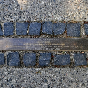 Metalltafel auf einer Kopfsteinpflasterstraße zur Erinnerung an die Deportation der Bewohner des Warschauer Ghettos durch Nazi-Deutschland im Jahr 1943.