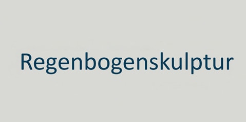 Text „Regenbogenskulptur“ in blauer Schrift auf hellgrauem Hintergrund.