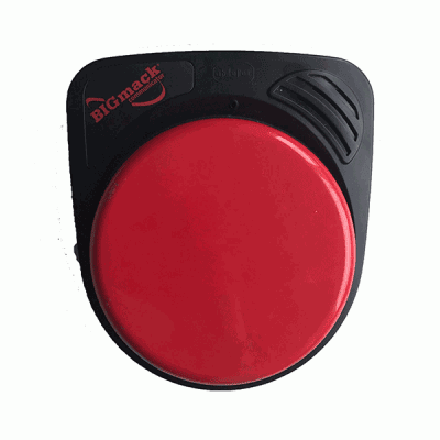 Ein adaptives Kommunikationsgerät mit einem großen roten Knopf mit der Aufschrift „BIGmack Communicator“ auf einem schwarzen Sockel. Oben rechts am Sockel befinden sich ein Mikrofon und ein Lautsprechergitter. Das Gerät dient der unterstützenden Kommunikation.