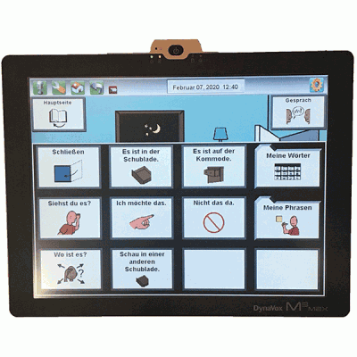 Ein DynaVox T10-Kommunikationsgerät, das ein Kommunikationsraster mit verschiedenen Symbolen und Sätzen auf Deutsch anzeigt. Die Sätze enthalten Optionen wie „Schließen“, „Siehst du es?“ und „Ich möchte das“.